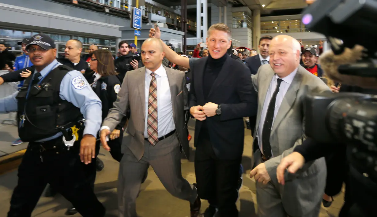 Mantan gelandang Manchester United, Bastian Schweinsteiger dikawal petugas keamanan setibanya di Bandara Internasional O'Hare, Chicago, Selasa (28/3). Kedatangan Schweinsteiger untuk bergabung dengan klub MLS, Chicago Fire. (AP Photo/Charles Rex Arbogast)