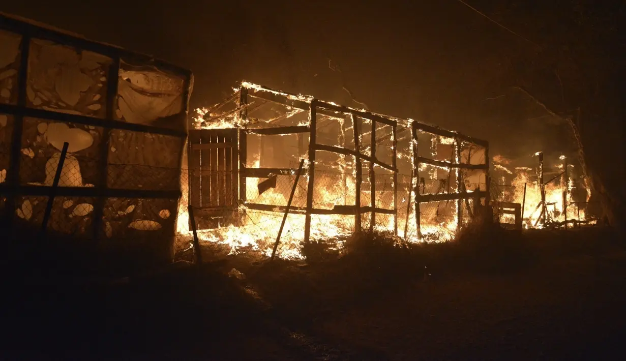Api membakar tenda darurat di kamp pengungsi Moria, Yunani, Rabu (9/9/2020). Kamp Moria ditempati lebih dari 12.500 pengungsi dan imigran. Sebagian besar dari mereka tiba di Moria antara tahun 2015 dan 2016, usai melarikan diri dari rumah di Irak dan Suriah. (AP Photo/Panagiotis Balaskas)