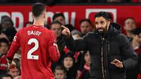 Pelatih kepala Manchester United asal Portugal, Ruben Amorim (kanan), berbicara dengan bek Manchester United asal Portugal bernomor punggung 02, Diogo Dalot (kiri), selama pertandingan Liga Inggris antara Manchester United dan Bournemouth di Old Trafford, Manchester, barat laut Inggris, Sabtu (27-12-2025) dini hari WIB. (PETER POWELL/AFP)