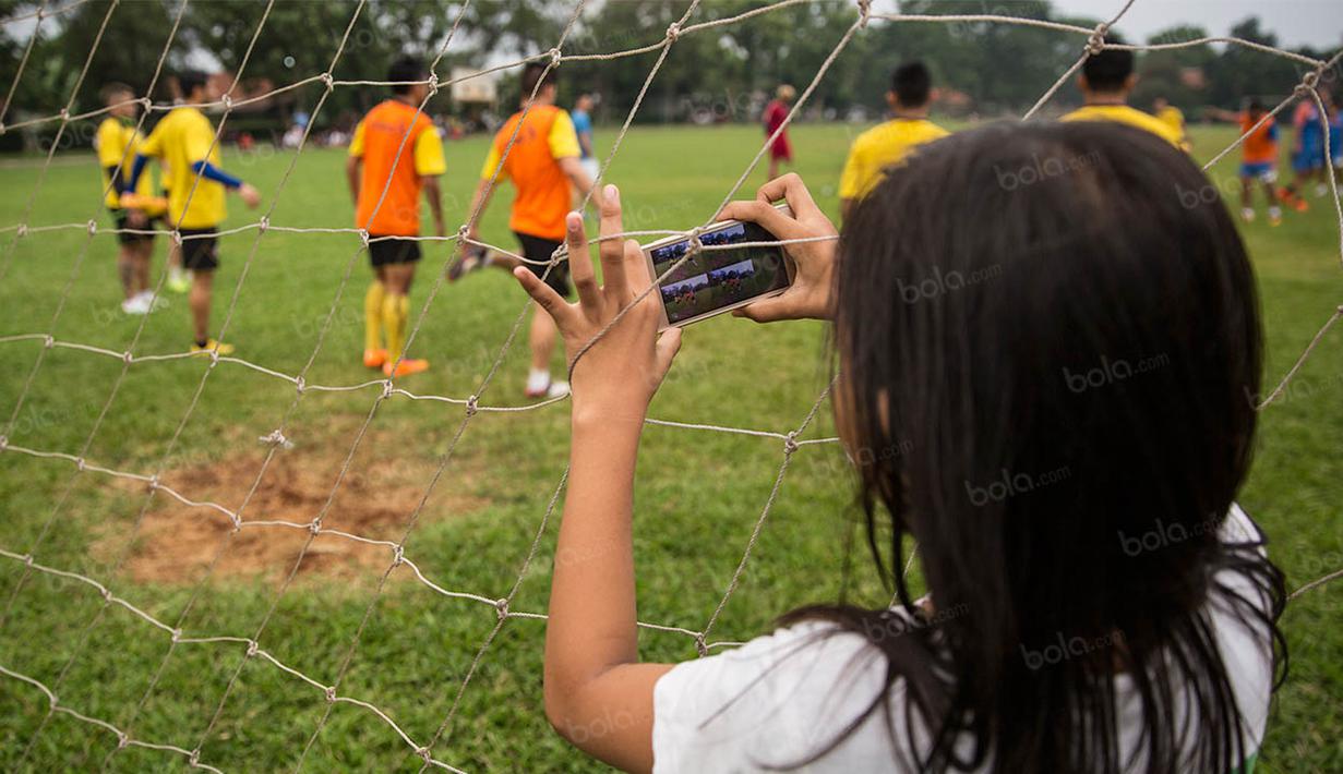 Seorang anak memotret latihan Arema Cronus jelang laga Torabika Soccer Championship 2016 melawan PS TNI di Lapangan Kostrad, Bogor, Jawa Barat, Sabtu (30/7/2016). (Bola.com/Vitalis Yogi Trisna)