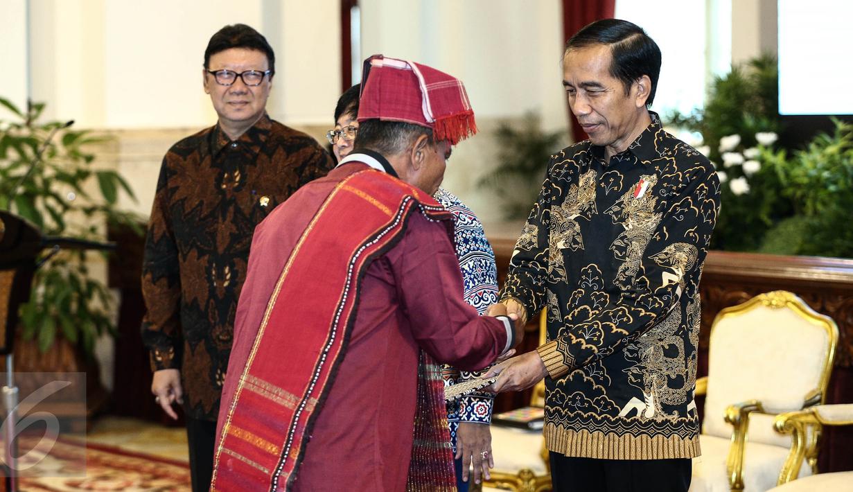 Presiden Joko Widodo menyerahkan surat keputusan pengakuan Hutan Adat kepada perwakilan pemangku hutan adat saat pencanangan pengakuan hutan adat di Istana Negara, Jakarta, Jumat (30/12). (Liputan6.com/Faizal Fanani)