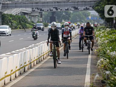 Pesepeda melintas di Jalan Jenderal Sudirman, Jakarta, Minggu (6/6/2021). Gubernur DKI Jakarta Anies Baswedan berencana menambah jalur sepeda sepanjang 101 kilometer di Jakarta pada tahun 2021. (Liputan6.com/Faizal Fanani)