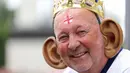 Seorang penggemar Inggris yang mengenakan telinga raksasa berpose sebelum pertandingan sepak bola Euro 2024 Grup C antara Denmark dan Inggris di Frankfurt Arena di Frankfurt am Main pada 20 Juni 2024. (Adrian DENNIS/AFP)