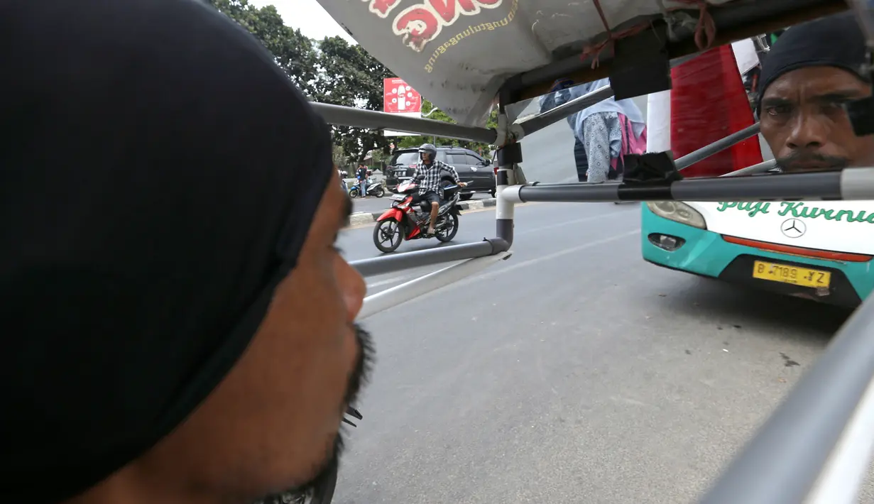 Medi Bastoni (43) melihat ke arah cermin saat jalan mundur dari Kabupaten Tulungagung menuju Jakarta di Bekasi, Jawa Barat, Kamis (22/8/2019). Aksi tersebut untuk menyampaikan permintaan bibit pohon yang akan ditanam di lereng kaki Gunung Wilis kepada Presiden Jokowi. (AP/Achmad Ibrahim)
