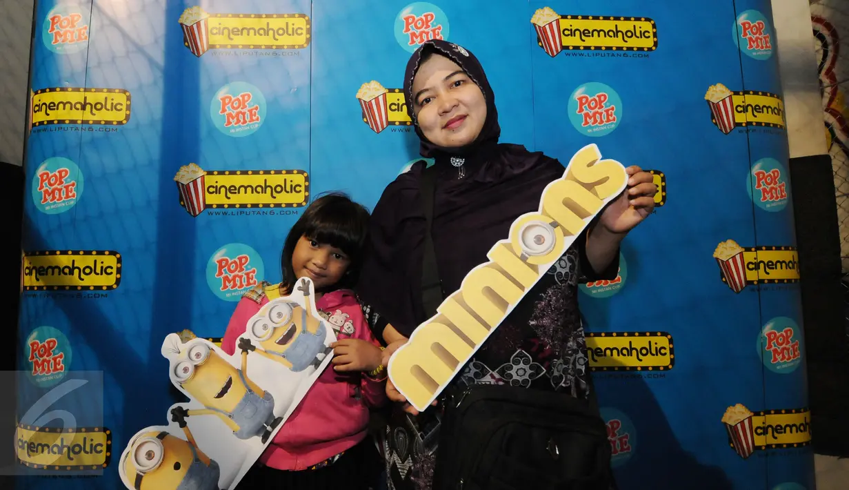Salah satu ibu dan anak bergaya di photo booth jelang menyaksikan film Minions di Bekasi Cyber Park, Minggu (28/6/2015). Film ini bergenre animasi yang dirilis Illumination Entertaiment dan cukup diminati anak-anak. (Liputan6.com/Helmi Fithriansyah)