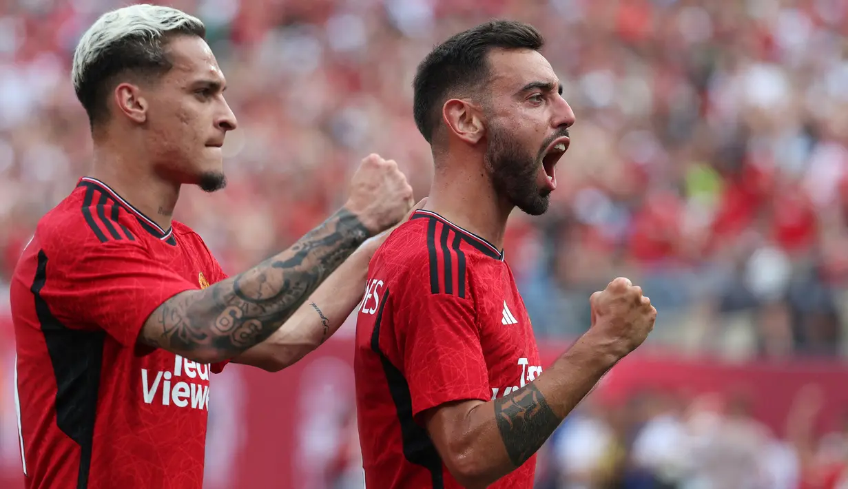 Manchester United terus menjaga hasil sempurna dalam laga pramusim 2023/2024 dengan sapu bersih tiga kemenangan. Kemenangan terakhir MU diraih atas Arsenal dengan skor 2-0 yang dilengkapi dengan kemenangan adu penalti 5-3 di MetLife Stadium, New Jersey, USA, Minggu (23/7/2023) pagi WIB. Sesuai regulasi penyelenggara, pertandingan dilanjutkan dengan babak adu penalti apapun hasil yang didapat pada laga normal. Dua gol kemenangan Setan Merah dicetak Bruno Fernandes pada menit ke-30 dan Jadon Sancho tujuh menit kemudian. Di babak adu penalti, semua penendang MU mampu mencetak gol, sementara satu penendang Arsenal gagal. (AFP/Getty Images/Al Bello)