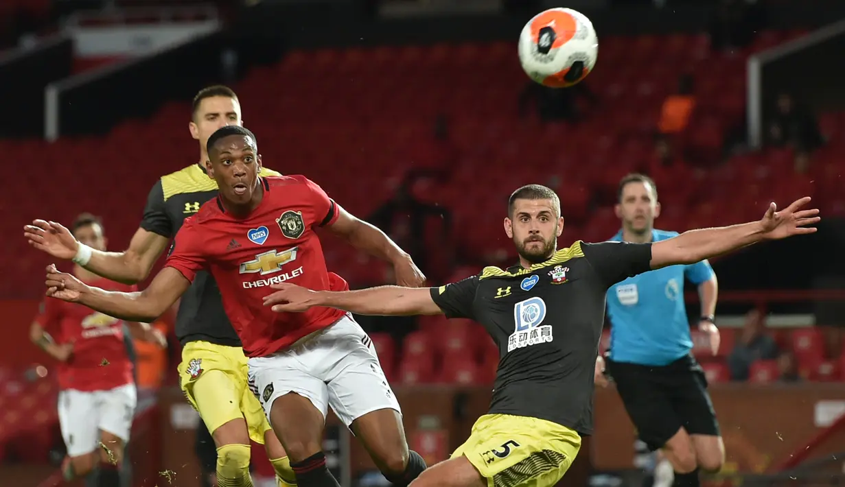 Striker Manchester United, Anthony Martial, berebut bola dengan pemain Southampton pada laga lanjutan Premier League pekan ke-35 di Stadion Old Trafford, Selasa (14/7/2020) dini hari WIB. Manchester United bermain imbang 2-2 atas Southampton. (AFP/Peter Powel/pool)