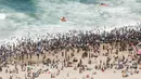 Ribuan wisatawan bersuka ria saat perayaan Tahun Baru di North Pier Beach, Durban, Afrika Selatan, 1 Januari 2022. Menurut polisi Afrika Selatan, hampir 50 ribu orang diperkirakan akan menghabiskan hari di pantai. (Rajesh JANTILAL/AFP)