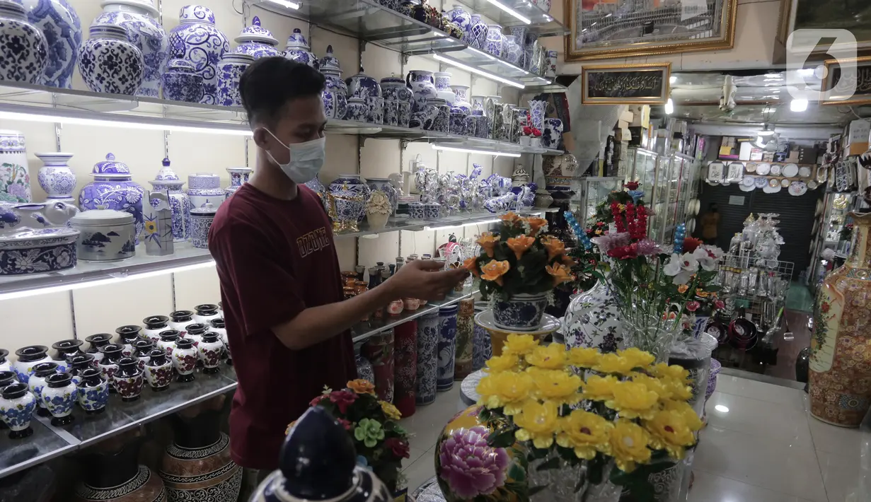Pembeli melihat produk keramik yang dijual di kios kerajinan keramik kawasan Tanjung Priuk, Jakarta Utara, Kamis (23/9/2021). Pedagang mengaku pasokan keramik menurun hingga 70 persen seiring dangan pembatasan produksi pabrik akibat perpanjangan PPKM. (Liputan6.com/Herman Zakharia)