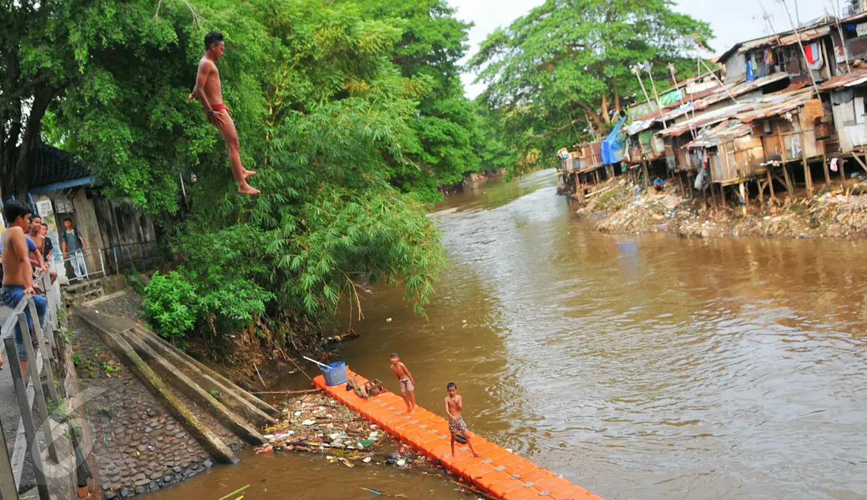Sejumlah anak-anak bantaran Sungai Ciliwung melompat ke sungai dari atas jembatan Manggarai, Jakarta, Rabu (18/5/2016). Kondisi air sungai Ciliwung saat ini lebih bersih dari tumpukan sampah. (Liputan6.com/Yoppy Renato)