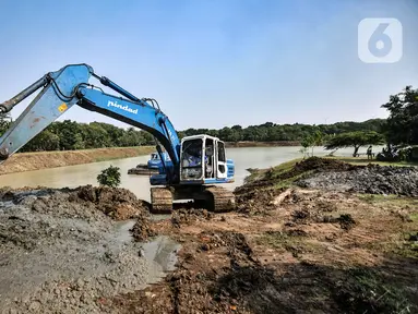 Petugas Sudin SDA Jakarta Timur menggunakan alat berat untuk mengeruk lumpur di Waduk Setu, Cipayung, Jakarta, Rabu (28/7/2021). Pengerukan lumpur ini dilakukan untuk mencegah terjadinya banjir saat musim hujan. (merdeka.com/Iqbal S. Nugroho)