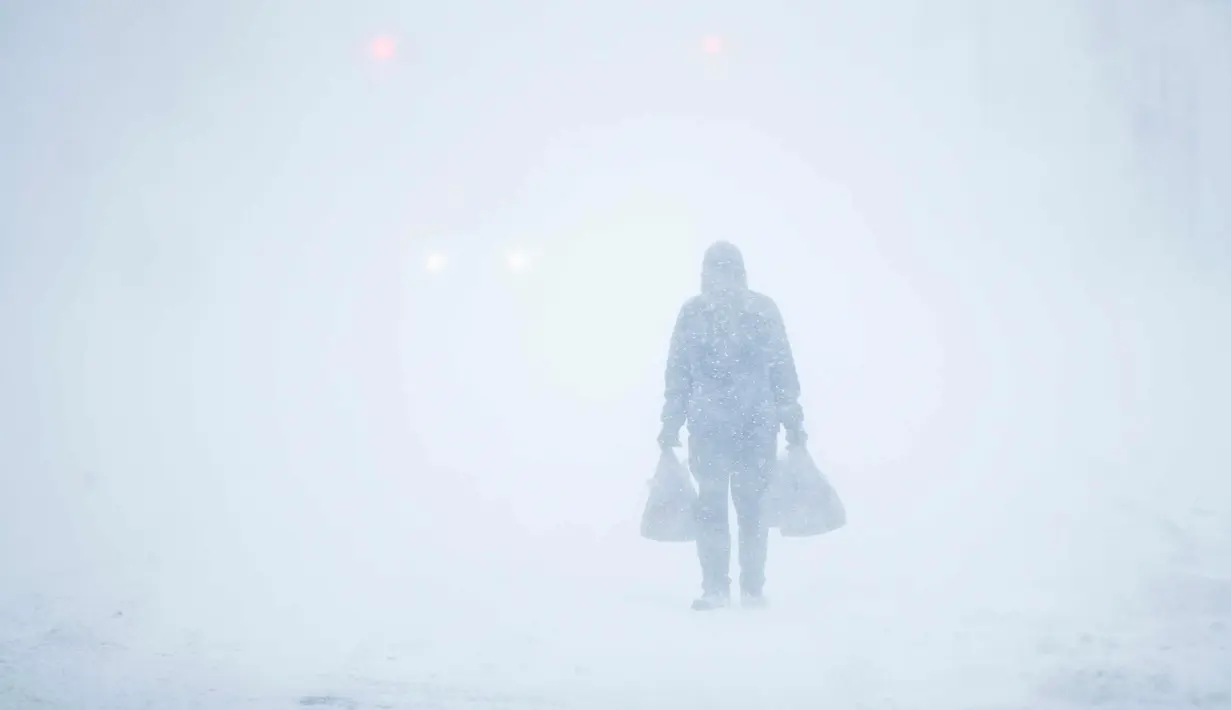 Seorang pria melewati badai salju di Atlantic City, NJ (4/1). Badai salju yang melanda sebagian Amerika Serikat telah membawa salju dan angin kencang. (AP Photo / Matt Rourke)
