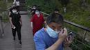 <p>Seorang pria mengenakan maskernya saat mengunjungi taman tepi sungai di Beijing, Rabu (18/5/2022). Sebagian besar Beijing di-lockdown, tetapi jalan-jalan jauh lebih sepi dari biasanya dengan banyak toko tutup dan orang-orang bekerja dari rumah ketika ibu kota China mencoba mengendalikan wabah COVID-19 yang kecil tetapi terus-menerus. (AP Photo/Ng Han Guan)</p>