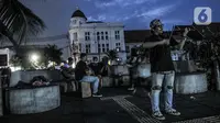 Pengamen memainkan musik di tengah sepinya Kota Tua, Jakarta, Kamis (31/12/2020). Pemprov DKI Jakarta menutup kawasan Kota Tua pada malam Tahun Baru kali ini guna mencegah kerumunan warga sebagai langkah memutus penyebaran COVID-19. (merdeka.com/Iqbal S. Nugroho)