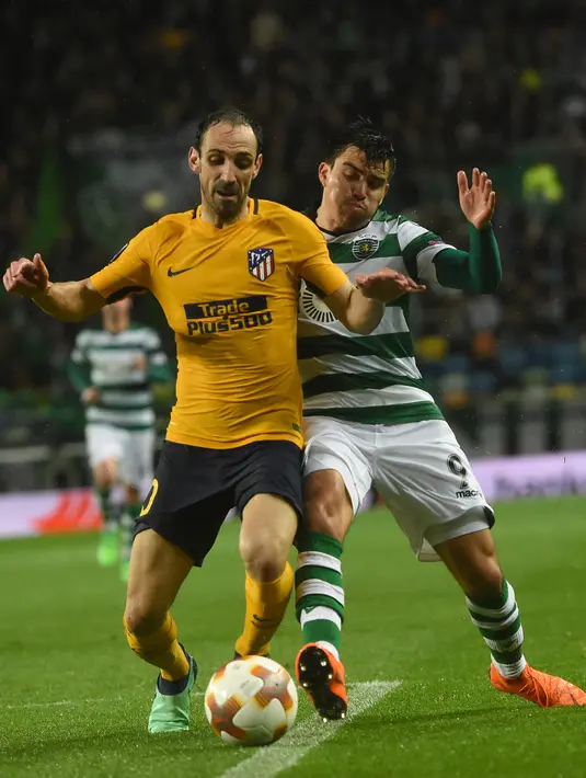 Bek Atletico Madrid, Juanfran berebut bola dengan pemain Sporting CP, Marcos Acuna pada leg kedua perempat final Liga Europa di Estadio Jose Avalade, Jumat (13/4). Atletico Madrid tetap maju ke semifinal meski kalah 0-1. (FRANCISCO LEONG / AFP)