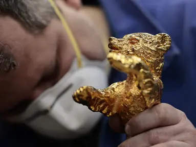 Seorang perajin mengerjakan trofi Berlinale Bear dari Festival Film Internasional Berlin ke-72 yang akan datang di pengecoran Noack di Berlin, pada 25 Januari 2022. Pabrik pengecoran Noack secara tradisional mempersiapkan semua trofi untuk Festival Film Internasional. (Hannibal Hanschke/POOL/AFP)