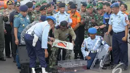 Tim SAR Gabungan memindahkan FDR (Flight Data Recorder) dari koper penyimpanan ke kotak khusus milik KNKT (Komite Nasional Keselamatan Transportasi) di Lanud Iskandar, Pangkalan Bun, Kalteng, Senin (12/01/2015). (Liputan6.com/Andrian M Tunay)