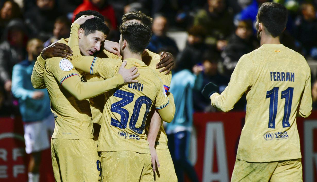 Pemain Barcelona merayakan gol yang dicetak oleh  Robert Lewandowski ke gawang Ceuta pada laga Copa del Rey di Stadion Alfonso Murube (19/1/2023). Barcelona berhasil berpesta gol saat melakoni pertandingan melawan Ceuta dalam 16 besar Copa del Rey. (AP Photo/Antonio Sempere)