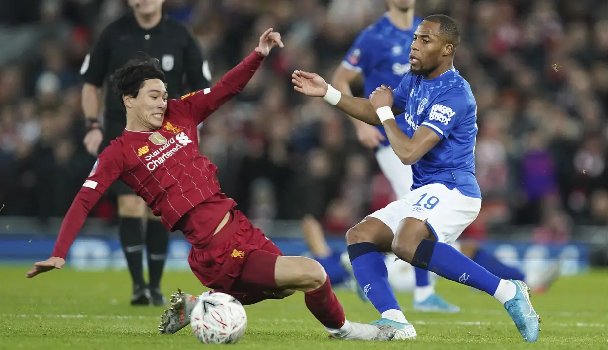 Gelandang Liverpool, Takumi Minamino berebut bola dengan pemain Everton, Djibril Sidibe pada pertandingan babak ketiga Piala FA di Anfield, Minggu (5/1/2020). Pada pertandingan ini Liverpool menang tipis 1-0 atas Everton melalui gol Curtis Jones. (AP Photo/Jon Super)