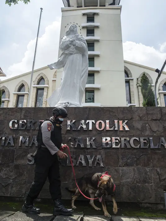 Polisi dengan menggunakan anjing pelacak melakukan penyisiran sebuah gereja di Surabaya menjelang Paskah setelah bom bunuh diri di katedral Makassar, Rabu (31/3/2021). Kegiatan tersebut merupakan upaya peningkatan pengamanan tempat ibadah, khususnya gereja di kota pahlawan. (Juni Kriswanto/AFP)
