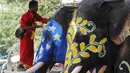 Seorang Pawang menaiki gading gajah saat festival air Songkran di Ayutthaya, Bangkok, Thailand (10/4/2015). Festival air songkoran menandai dimulainya Tahun Baru tradisional Thailand. (REUTERS/Chaiwat Subprasom)