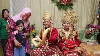 Pesta pernikahan unik di Kota Palembang, sepasang pengantin memakai atribut yaitu ular Piton Molurus yang merupakan peliharaan pengantin pria, Sadam Maulana (Dok. Pribadi Sadam Maulana / Nefri Inge)
