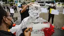 Aksi berupa patung es dalam pengantaran 1000 kartu pos oleh aktivis Greenpeace kepada Presiden Joko Widodo di kawasan Monumen Patung Kuda, Jakarta, Rabu (10/11/2021). Kartu pos itu berisikan agar pemerintah melihat dampak perubahan iklim terhadap ekosistem di sekitar. (Liputan6.com/Faizal Fanani)