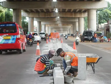 Pekerja menyelesaikan pembuatan separator atau pembatas jalan di Jalan Margasatwa, Andara, Jakarta Selatan, Kamis (21/11/2019). Separator itu dibuat guna memisahkan dua lajur sehingga meminimalisasi tingkat kecelakaan. (Liputan6.com/Immanuel Antonius)