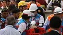 Petugas medis mengevakuasi salah satu korban kebakaran yang melanda Mal Larcomar di pusat Ibu Kota Peru, Lima, Rabu (16/11). Lokasi kebakaran berada di dekat hotel yang akan digunakan para delegasi KTT APEC tinggal. (REUTERS/Guadalupe Pardo)