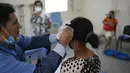 Seorang dokter melakukan terapi akupunktur pada pasien terpapar virus Corona COVID-19 yang baru pulih di pusat kesehatan yang dikelola pemerintah di lingkungan Coche di Caracas, Venezuela pada 25 Februari 2021. (AP Photo / Matias Delacroix)