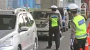 Polisi memeriksa kendaraan di Pos Penyekatan Jalur Mudik, Gerbang Tol Cikarang Barat, Bekasi, Rabu (20/5/2020). Sejak 24 April sampai 19 Mei 2020, Ditlantas Polda Metro Jaya telah memutarbalikkan 20.972 kendaraan mudik Lebaran yang hendak meninggalkan Jabodetabek. (Liputan6.com/Herman Zakharia)