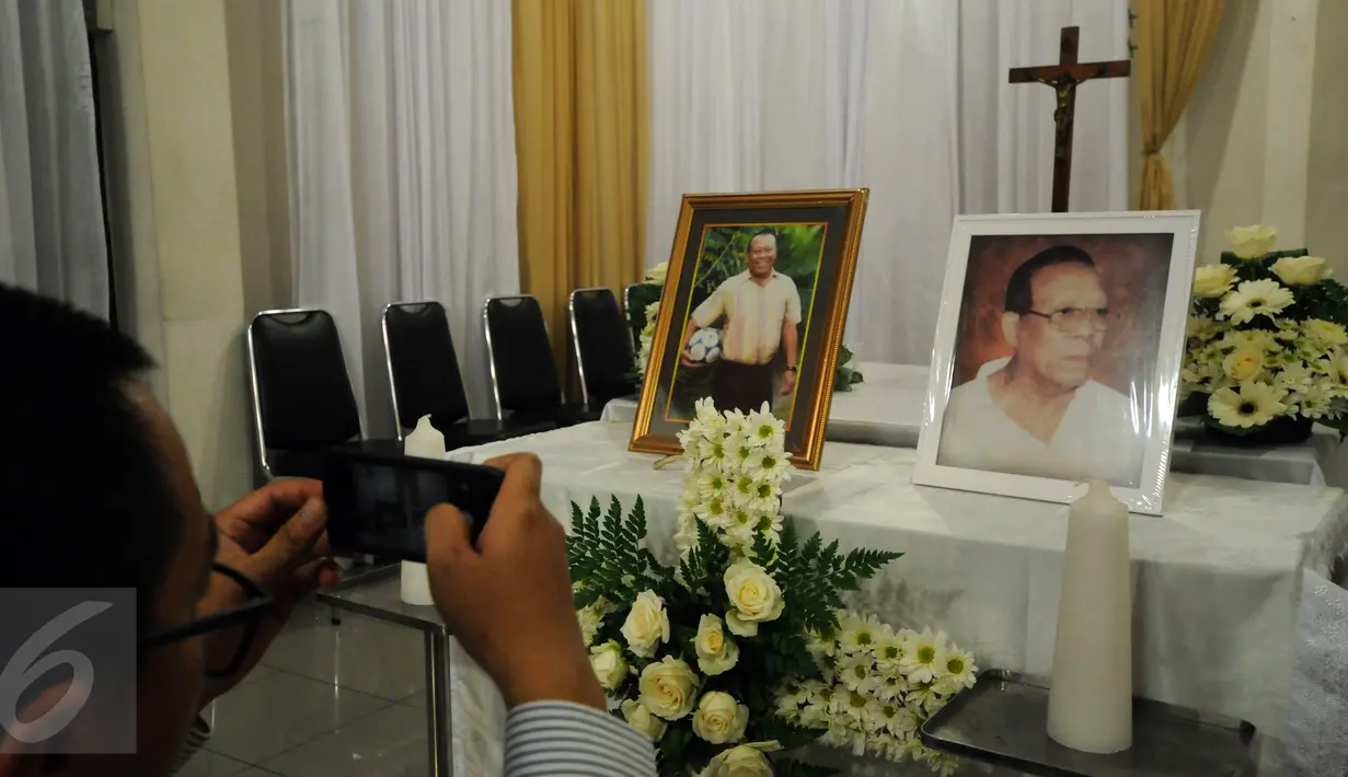 Seorang kerabat mengabadikan gambar legenda sepakbola Indonesia. Sinyo Aliandoe yang meninggal dunia di Jakarta, Rabu (18/11/2015). Sinyo wafat pada usia 77 tahun dan disemayamkan di Rumah Duka St Carolus Jakarta. (Liputan6.com/Helmi Fithriansyah) 