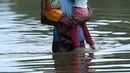 Seorang pria menggendong dua anak sambil menerobos banjir akibat hujan lebat di Pugoda, Senin (16/5). Banjir dan tanah longsor di Sri Lanka menelan sedikitnya delapan korban jiwa, termasuk seorang bayi berusia 10 bulan. (Ishara S.KODIKARA/AFP)