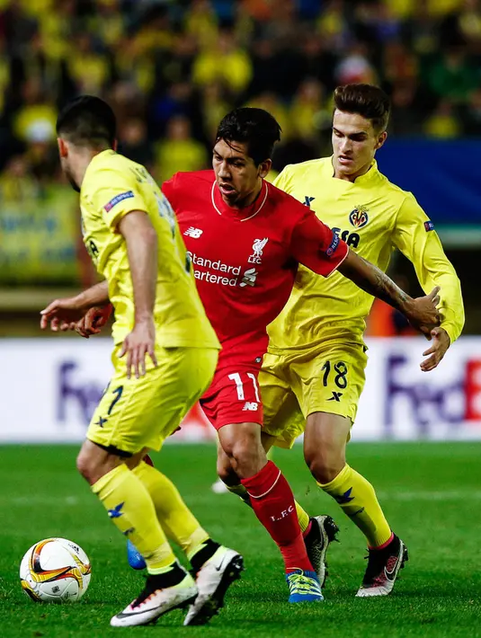 Penyerang Liverpool, Roberto Firmino (tengah) berusaha melewati dua pemain Villarreal pada leg pertama liga Europa di stadion El Madrigal, Spanyol, (28/4). Villarreal menang atas Liverpool dengan skor 1-0. (AFP PHOTO / Biel Alino)