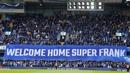 Suporter membentangkan spanduk sambutan untuk Frank Lampard saat melawan Brighton and Hove Albion pada pekan ke-31 Premier League 2022/2023, Sabtu (15/4/2023). Frank Lampard menjalani laga kandang pertamanya pasca-pelantikan kembali sebagai pelatih Chelsea. Momen comeback sang legenda ke Stamford Bridge berakhir pahit saat menjamu Brighton & Hove Albion. (AP Photo/Kirsty Wigglesworth)