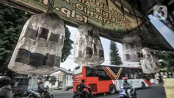 Sejumlah botol untuk air zamzam tergantung di depan toko oleh-oleh haji milik Budi di Jalan Raya Pondok Gede, Jakarta, Rabu (21/7/2021). (merdeka.com/Iqbal S. Nugroho)