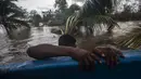 Seorang pria menarik kano di daerah banjir yang disebabkan oleh Sungai Wawa Boom setelah melintas Badai Iota di Bilwi, Puerto Cabezas, Nikaragua (18/11/2020). Badai Iota telah menewaskan sedikitnya sembilan orang saat menghancurkan rumah, menumbangkan pohon dan menggenangi air. (AFP/Inti Ocon)