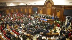 Demonstran mendengarkan pembicara saat masuk Gedung Parlemen memprotes kesepakatan untuk menghentikan pertempuran di wilayah Nagorno-Karabakh, Yerevan, Armenia, Selasa (10/11/2020). PM Armenia Nikol Pashinian menyerukan diakhirinya pertempuran dengan Azerbaijan. (AP Photo/Dmitri Lovetsky)