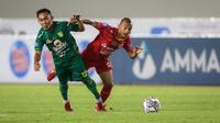 Pemain Persebaya Surabaya, Rendi Irawan Saputra (kiri) dan pemain Persija Jakarta, Riko Simanjuntak berebut bola saat laga pekan kesembilan BRI Liga 1 2021/2022 antara Persija Jakarta melawan Persebaya Surabaya di Stadion Manahan, Solo, Selasa (26/10/2021). (Bola.com/Bagaskara Lazuardi)