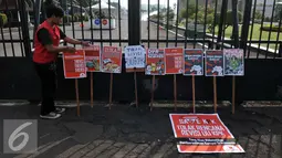 Mahasiswa dari BEM-se Indonesia melakukan Aksi meletakan poster di depan Gedung DPR-MPR, Senayan, Jakarta, Selasa (23/2/2016). Dalam Aksinya mereka menuntut "Menolak Revisi UU KPK". (Liputan6.com/Johan Tallo)