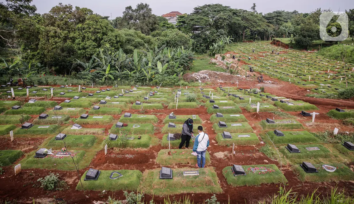 Umat Muslim menabur bunga di makam keluarga saat berziarah di Tempat Pemakaman Umum (TPU) Pondok Ranggon, Jakarta, Minggu (04/04/21). Menjelang bulan Ramadan umat muslim melakukan ziarah kubur untuk mendoakan keluarga dan kerabatnya yang telah wafat. (Liputan6.com/Faizal Fanani)
