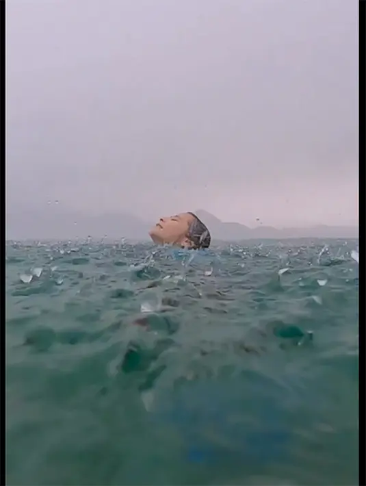 Dalam video tersebut, Prilly tampak menikmati gelombang air laut hingga tetesan air hujan. Prilly mengapung sambil memejamkan matanya untuk menikmati setiap tetes hujan. [Instagram/prillylatuconsina96]