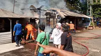 Petugas DPKP Kota Depok melakukan pemadaman warkop dan Lapo yang terbakar di dekat Jembatan Panus, Kecamatan Pancoran Mas, Kota Depok. (Istimewa)