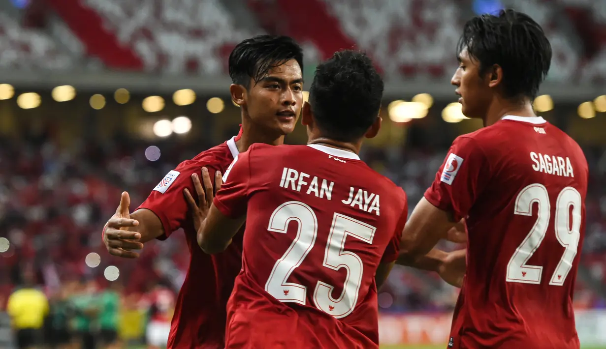 Bek Timnas Indonesia, Pratama Arhan (kiri) berselebrasi dengan rekan setimnya usai mencetak gol ke gawang Singapura pada pertandingan leg kedua semifinal Piala AFF 2020 di National Stadium, Sabtu (25/12/2021). Indonesia akan bertemu antara Thailand dan Vietnam di babak final. (AFP/Roslan Rahman)