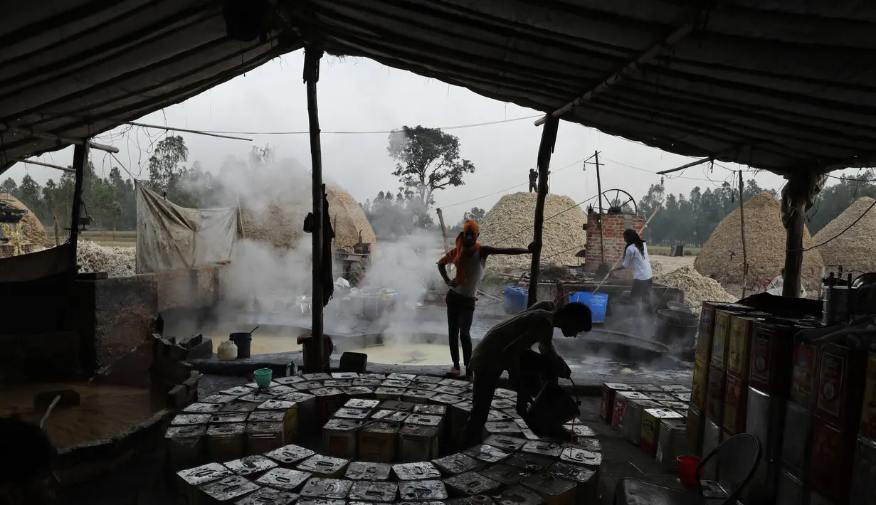 Seorang pekerja mengisi kaleng dengan gula merah yang sudah disiapkan di pinggiran Bareilly, India, Selasa (23/3/2021).  Jaggery adalah gula tradisional yang tidak dimurnikan yang dikonsumsi di banyak bagian Asia, terbuat dari molase tebu dan nira kurma. (AP Photo/Rajesh Kumar Singh)