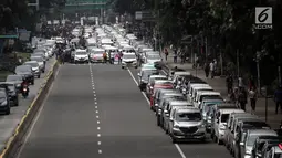 Suasana saat ratusan sopir taksi online memarkir mobilnya di Jalan Medan Merdeka Barat, Jakarta, Rabu (14/2). Para pengemudi menolak Permenhub Nomor 108 karena dianggap memberatkan. (Liputan6.com/Arya Manggala)
