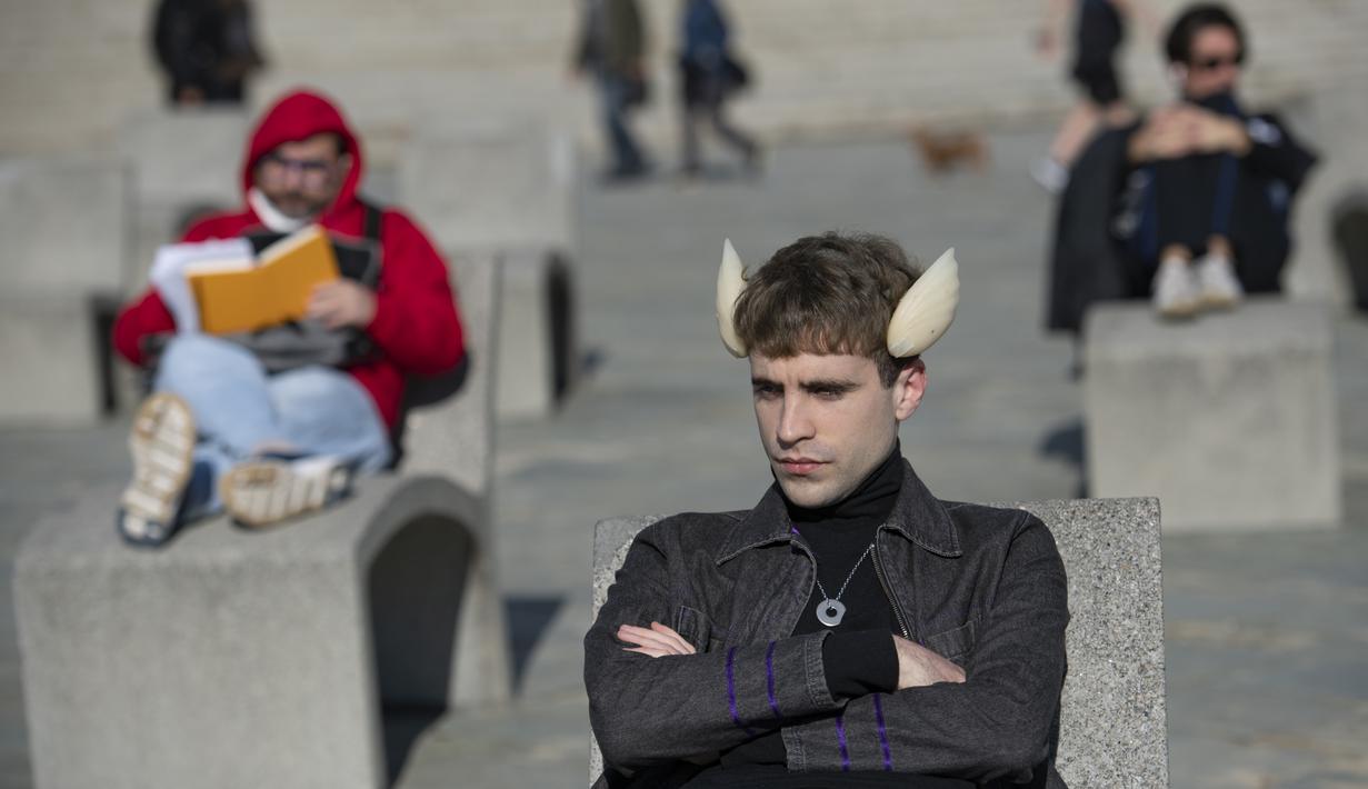 Penampilan seniman Spanyol dan aktivis Trans-Species, Manel De Aguas (24) di sebuah pantai di Barcelona Selas (12/1/2021). Seniman tersebut menanamkan "Sirip Cuaca" di samping kepala yang memungkinkannya untuk merasakan tekanan atmosfer, kelembapan dan suhu. (Josep LAGO / AFP)