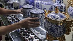 Pembeli melihat produk keramik yang dijual di kios kerajinan keramik kawasan Tanjung Priuk, Jakarta Utara, Kamis (23/9/2021). Pedagang mengaku pasokan keramik menurun hingga 70 persen seiring dangan pembatasan produksi pabrik akibat perpanjangan PPKM. (Liputan6.com/Herman Zakharia)