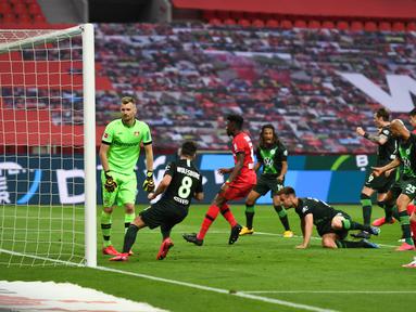 Bek Wolfsburg, Marin Pongracic, saat mencetak gol ke gawang Bayer Leverkusen pada laga pekan ke-28 Bundesliga di Stadion Bay Arena, Selasa (26/5/2020) waktu setempat. Wolfsburg menang 4-1 atas Bayer Leverkusen. (AFP/Marius Becker/POOL)