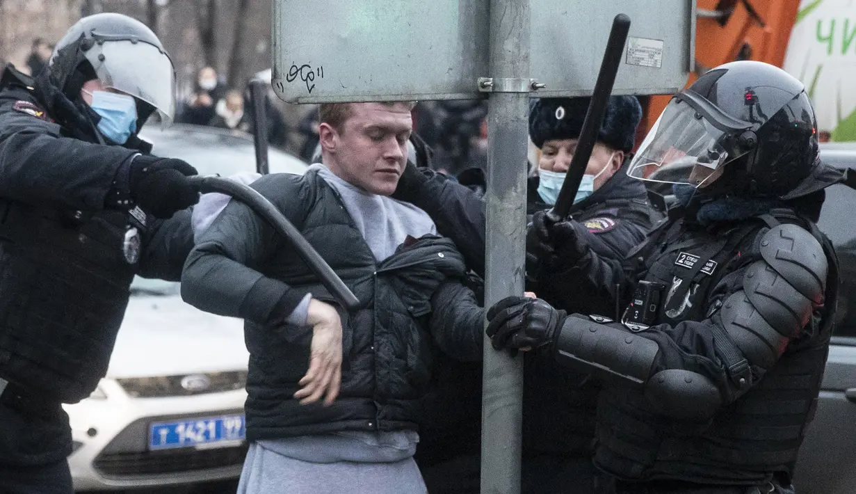 Petugas polisi menahan seorang pria selama protes terhadap pemenjaraan pemimpin oposisi Alexei Navalny di Moskow, Rusia, Sabtu (23/1/2021). Puluhan ribu pendukung melakukan unjuk rasa di seluruh Rusia setelah Navalny ditahan di bandara Moskow. (AP Photo/Pavel Golovkin)
